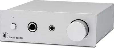 A silver headphone amplifier on a light gray background.