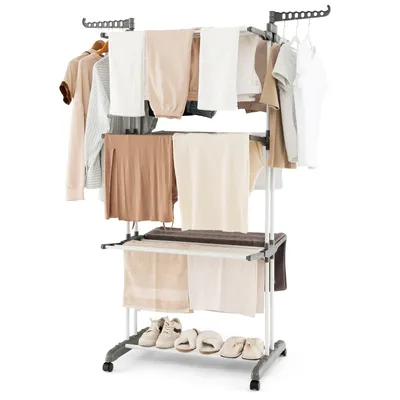 A multi-tiered drying rack with clothes and towels on it, and shoes on the bottom shelf.