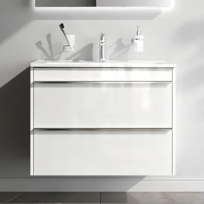 A white bathroom vanity with a sink and faucet mounted on a light gray wall.