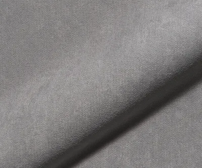 A close-up, angled view of a gray fabric surface, likely a boxspring frame.