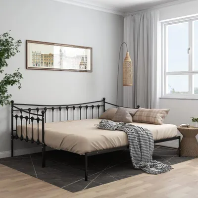 A bedroom scene with a daybed, pillows, and a blanket.