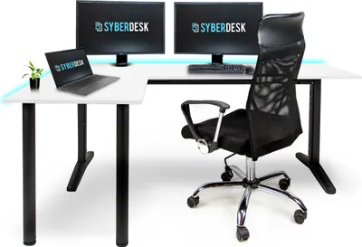 A gaming desk setup with two monitors, a laptop, and a chair.