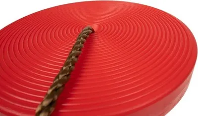 A close-up view of a red disc swing with a braided rope attached.
