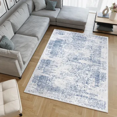 A living room with a sectional sofa and a rug.