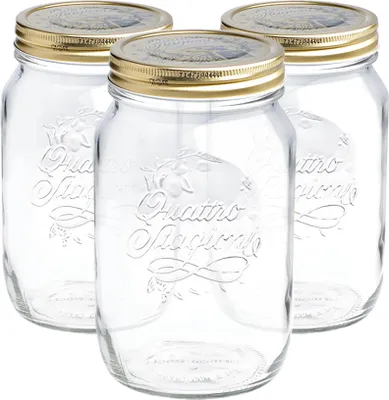 Three clear glass mason jars with gold lids are arranged in a group against a white background.