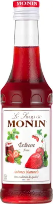 A bottle of Monin strawberry syrup against a white background.