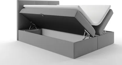A grey upholstered bed frame with the mattress lifted to reveal storage compartments underneath.