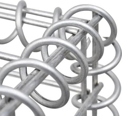 A close-up view of a metal gabion structure, showing the interlocking wire coils.