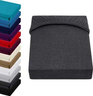 A stack of colorful fitted sheets and a single gray fitted sheet.