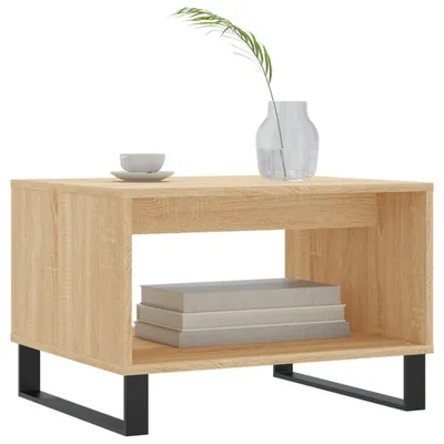 A light brown wooden coffee table with a black metal frame sits on a white background. There is a small white bowl and saucer on the table, and a glass vase with a single green leaf.