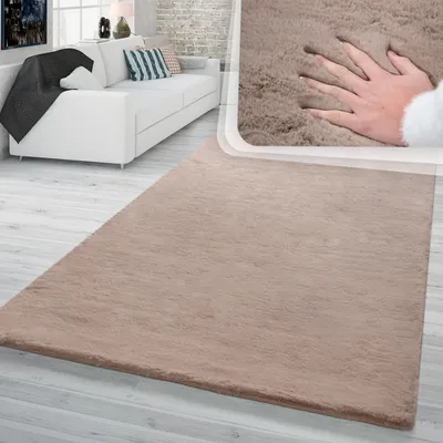 A living room scene with a white sofa and a beige rug. A close-up inset shows a hand pressing into the soft texture of the rug.