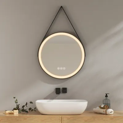 A modern bathroom vanity with a round LED mirror above a vessel sink.