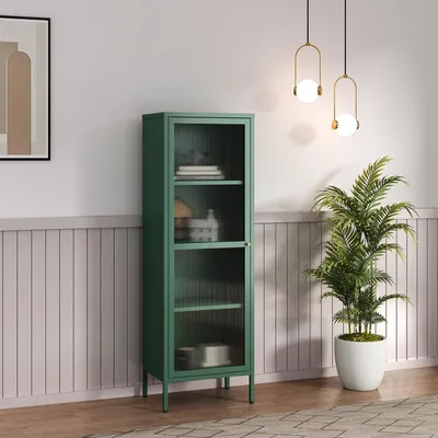 A tall, narrow green cabinet with glass doors stands in a room with a plant and decorative lighting.