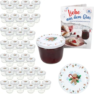 A collection of small glass jars with decorative lids, a jar filled with jam, a recipe book, and a decorative plate, all with a Christmas theme.