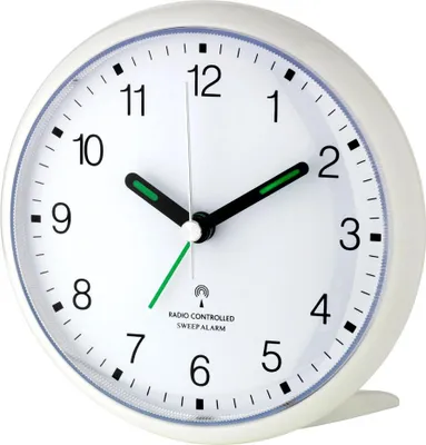A close-up, studio shot of a white analog alarm clock.