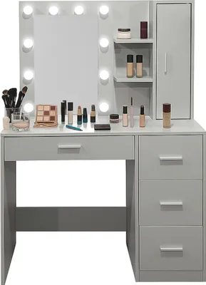 A makeup vanity with a mirror and lights, displaying various makeup products.