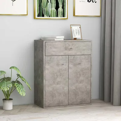 A concrete-effect cabinet with a drawer and two doors, next to a potted plant and framed artwork on a wall.