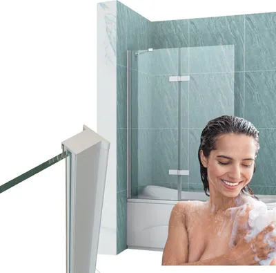 A woman is showering in a bathtub with a glass shower enclosure.