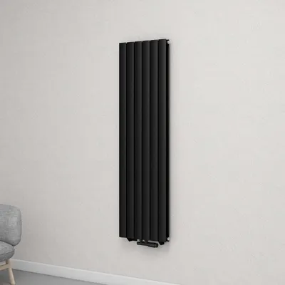 A black vertical radiator mounted on a textured white wall.