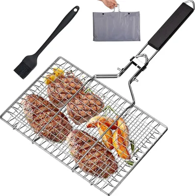 A grill basket filled with steaks and potato wedges, along with a basting brush and a carrying bag, is displayed against a white background.