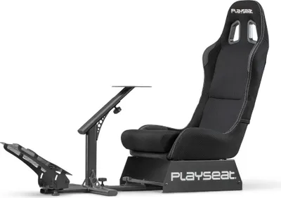 A black gaming chair with a pedal stand and a small table attached.