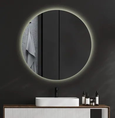 A modern bathroom vanity with a sink and a round LED mirror above it.