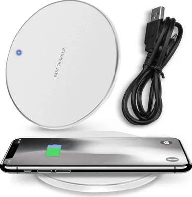 A white wireless charger with a black USB cable and a smartphone on top, charging.