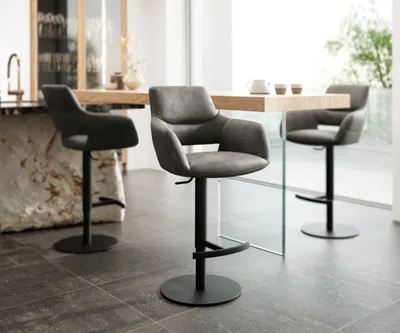 Three bar stools are arranged around a table in a modern kitchen or dining area.
