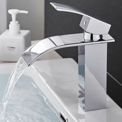 A modern chrome faucet with water flowing into a sink.