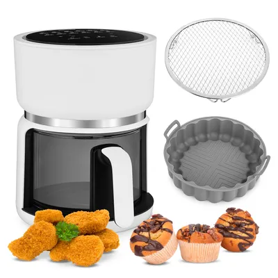 A white air fryer with various accessories and food items displayed around it.