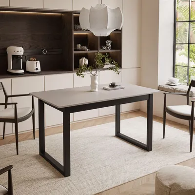 A dining table set in a modern kitchen with chairs and a pendant light.