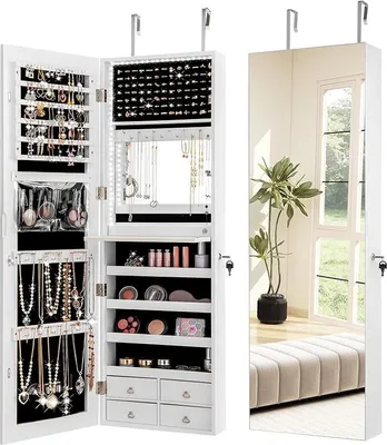 A white jewelry cabinet with a mirror on the right side, showing a room interior with a plant and a bench.