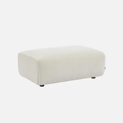 A cream-colored bouclé ottoman is shown against a plain white background.
