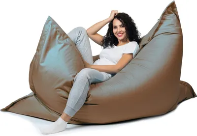 A woman is sitting on a large beanbag chair.