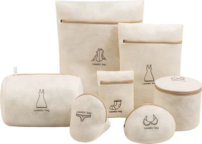 A collection of seven beige mesh laundry bags with zippers and embroidered clothing icons, arranged on a white background.