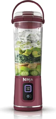 A Ninja personal blender filled with ingredients and ice, shown against a white background.