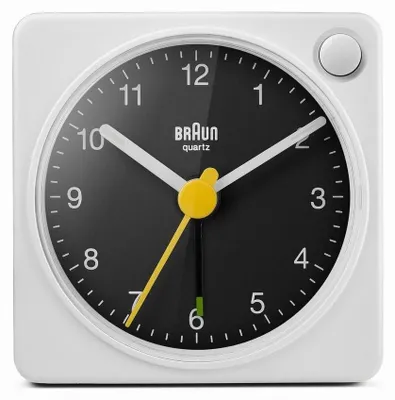 A close-up studio shot of a white Braun alarm clock with a black face.