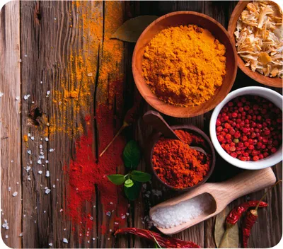 A collection of spices and seasonings arranged on a rustic wooden surface.