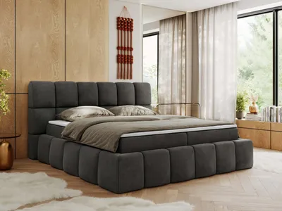 A bedroom scene featuring a large boxspring bed.