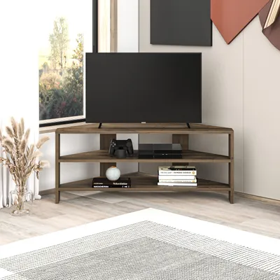 A modern corner TV stand with a television, game console, and books.
