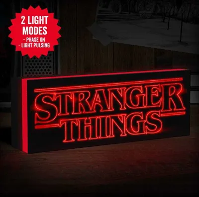 A Stranger Things logo light is displayed on a wooden surface, with a hint of a background scene.