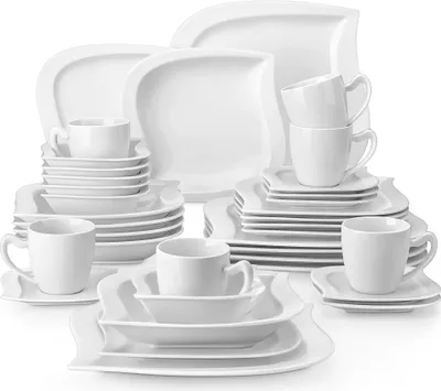 A collection of white porcelain dinnerware and cups arranged on a white background.