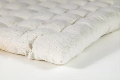A close-up, angled view of a tufted cushion on a white background.