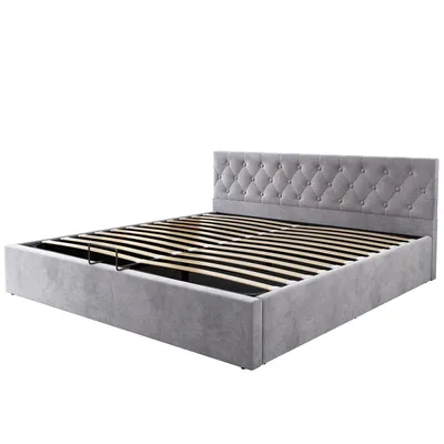 A grey upholstered bed frame with a tufted headboard and a slatted base, shown from a diagonal angle.