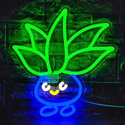 A neon LED light shaped like a cartoon vegetable character is mounted on a brick wall.