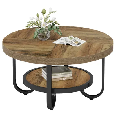 A round, two-tiered coffee table with a wood-grain finish and black metal legs, decorated with a vase of flowers and a magazine.