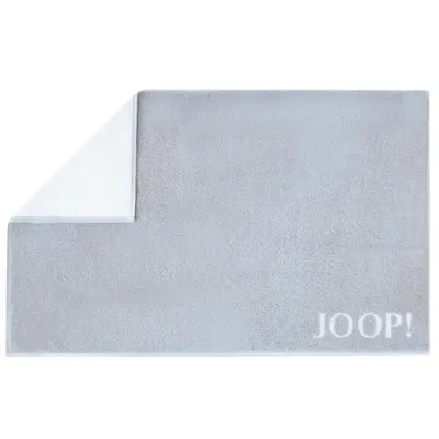 A light gray bath mat with a white corner folded back, revealing the white underside. The brand name 'JOOP!' is visible in white text on the bottom right corner of the mat.