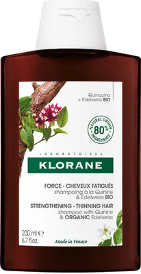 A bottle of Klorane shampoo with botanical illustrations.