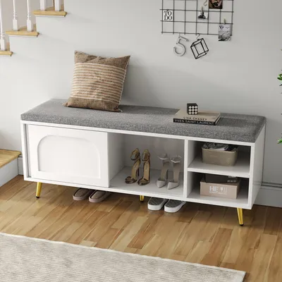A shoe bench with storage in a hallway next to stairs.