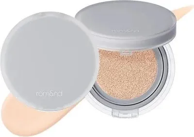 A cushion foundation compact with the lid open, showing the product inside and a swatch of foundation.